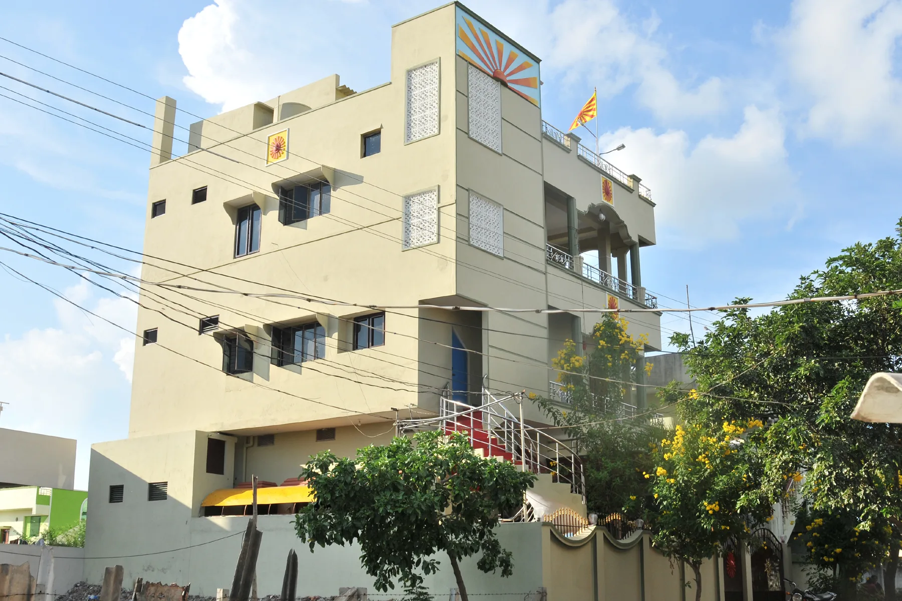 Exterior of the AYTAS Guntur hub, showing its sunburst façade and rooftop flag.