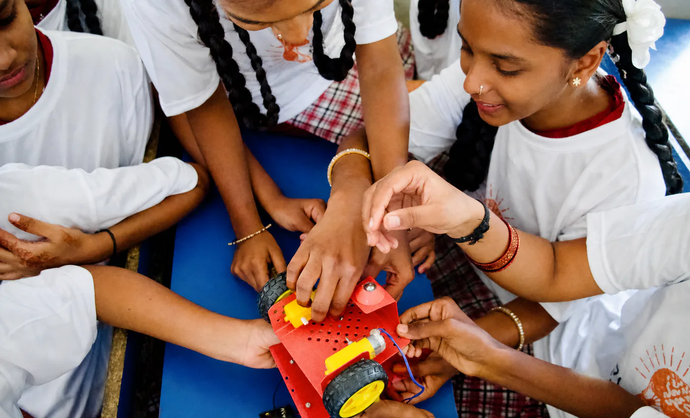 Students gathered around laptops and an electronics kit at the AYTAS hub